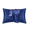 A dark blue luxury mulberry silk pillow cover with a draped fold.