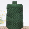 A spool of dark green crochet ice rope with a gray top, resting on a woven mat.