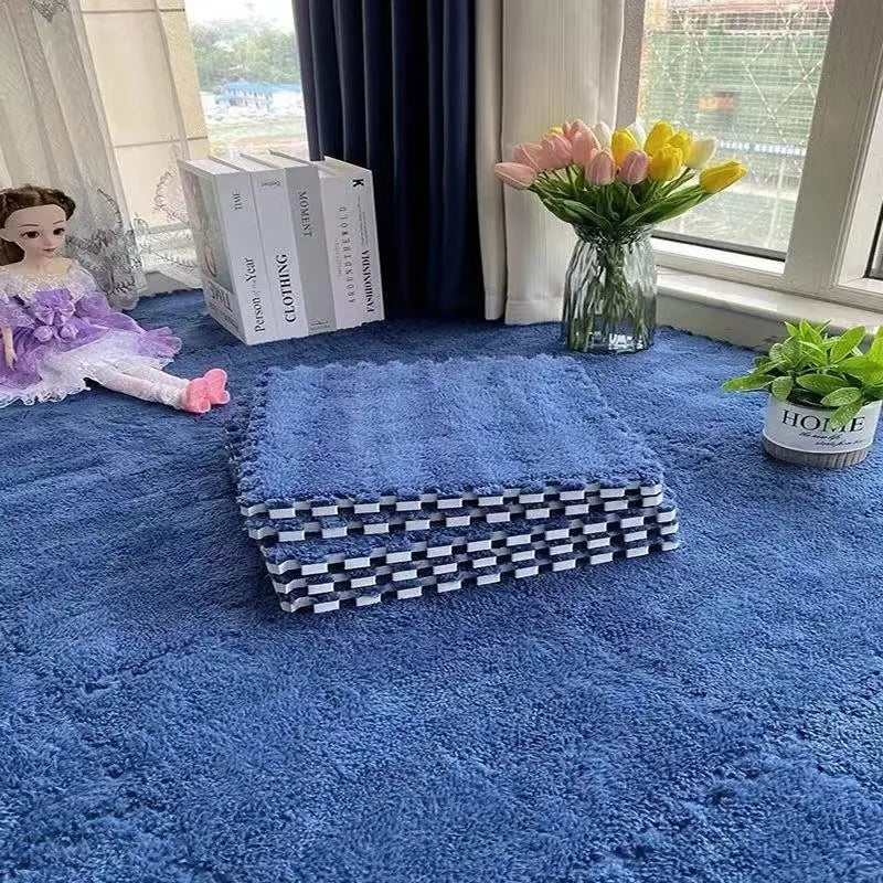 A deep blue plush interlocking puzzle rug mat placed on a floor, next to a window with flowers and books.