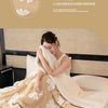 A beige and white light luxury flannel blanket draped over a bed, showing its soft texture.
