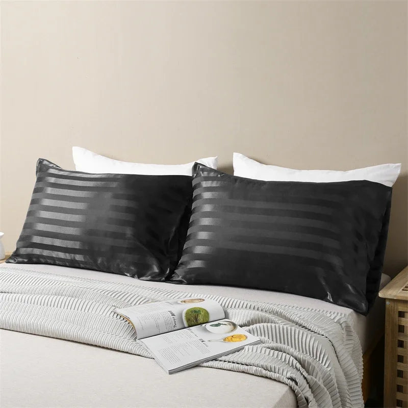 Black and white striped pillow covers with white pillows on a bed