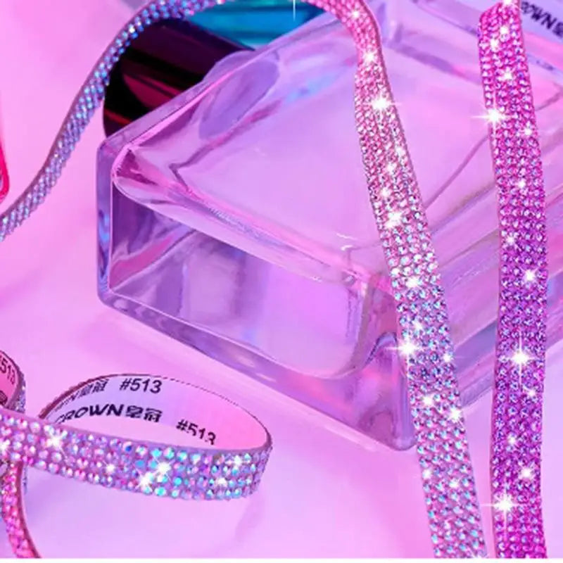 Pink crystal rhinestone sticker ribbon with diamond trim laid out next to a clear box.