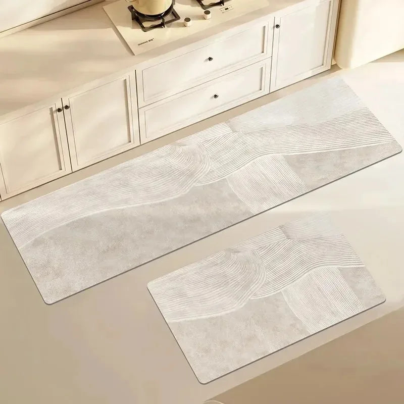 A rectangular gray waterproof non-slip kitchen floor mat with subtle wavy lines is displayed on a light-colored cabinet.