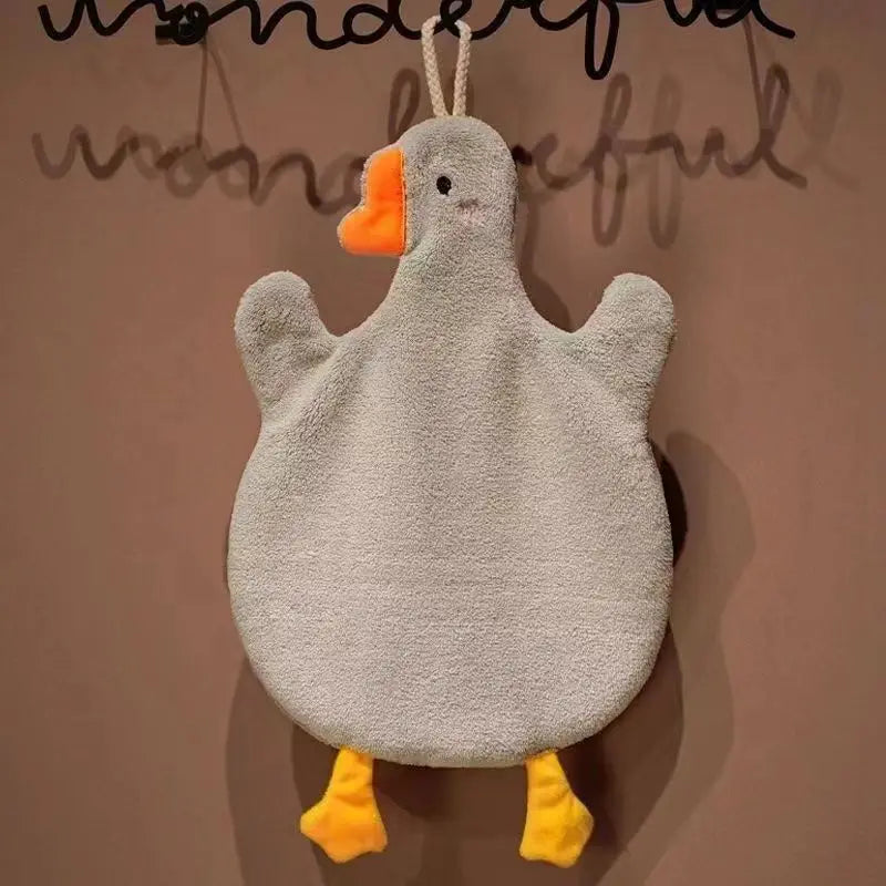 A cute cartoon goose hanging towel with orange beak and yellow feet against a neutral background.