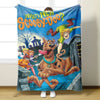 A blue flannel throw blanket featuring a Scooby-Doo graphic with the text What's New Scooby-Doo