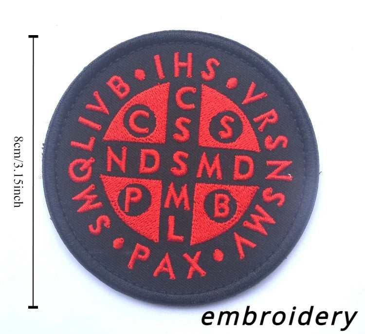 A black embroidered patch featuring red text and symbols on a circular background.