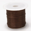 A spool of brown multicolor elastic beading cord with a white plastic core.