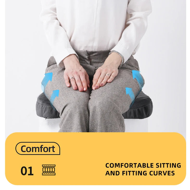 A person is sitting on a gray ergonomic seat cushion, demonstrating the fitting curves for comfortable sitting.