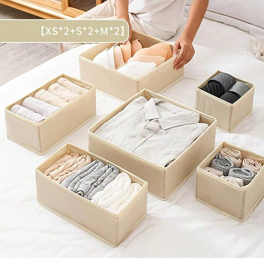 A set of beige foldable underwear organizers containing various shades of socks and underwear.