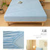 Light blue fitted bed sheet set displayed on a wooden bed frame with pillows and bedside tables.