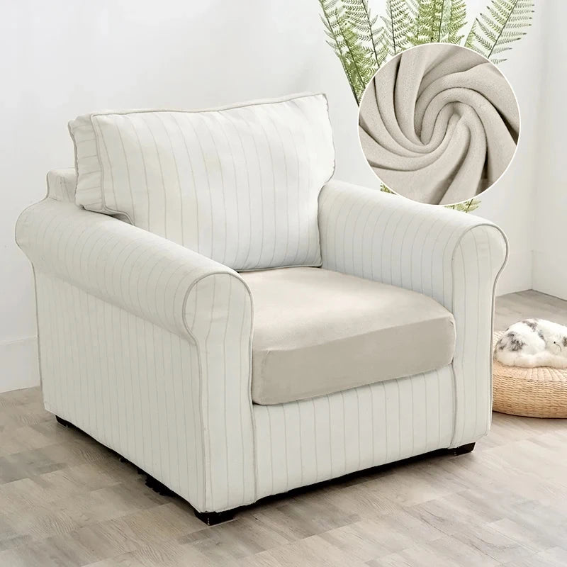 A cream-colored upholstered armchair with vertical stripes and a light beige cushion sits on a wooden floor.