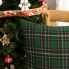 A close-up of a dark green tartan plaid decorative throw pillow cover on a Christmas tree.