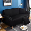 A black universal stretch sofa and chair slipcover placed in a modern living room setting.
