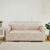 A beige PU leather sofa slipcover in a modern style placed in a bright room.