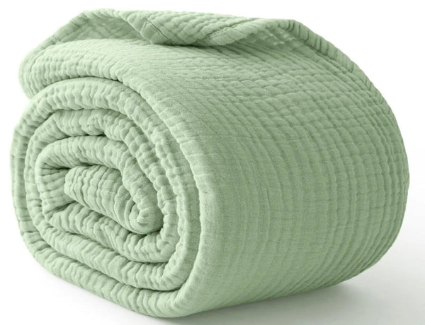 A rolled ultra-soft 100% cotton gauze blanket in a pale sage green color.