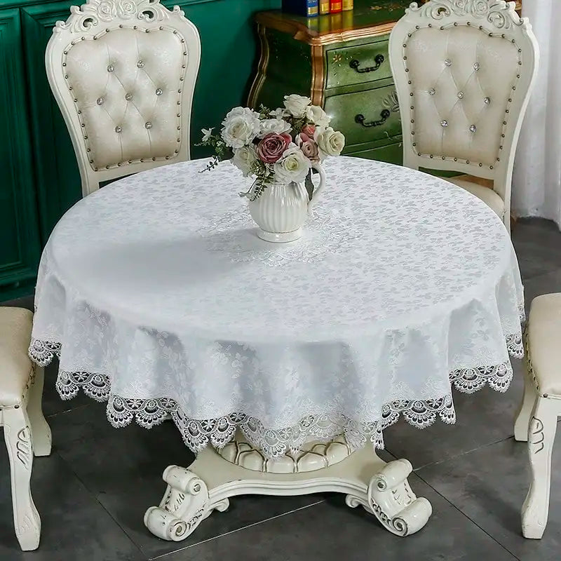 A round white lace tablecloth with an elegant embroidered edge set on a dining table surrounded by antique chairs.