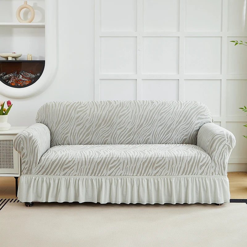 A light beige anti-slip jacquard sofa slipcover with a zebra stripe pattern displayed indoors.