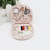 A pink portable DIY sewing box containing various sewing tools and threads for home crafts.