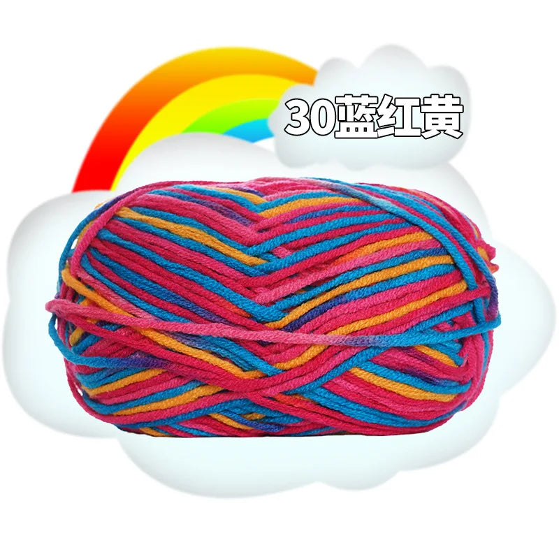 A ball of multi-colored yarn, featuring pink, blue, and orange threads, is shown against a white cloud with a rainbow in the 