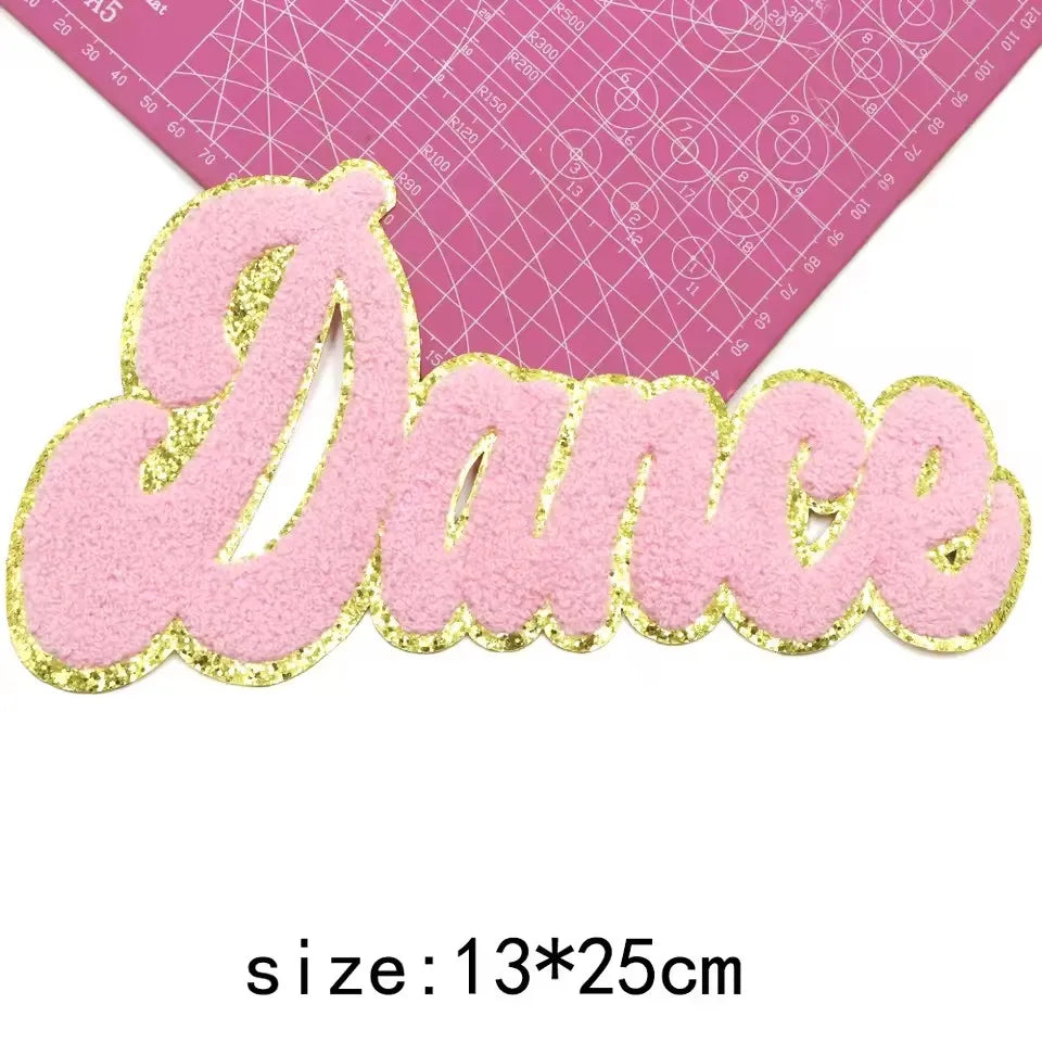 Pink felt embroidered cheer letter patch spelling the word Dance with gold glitter outline