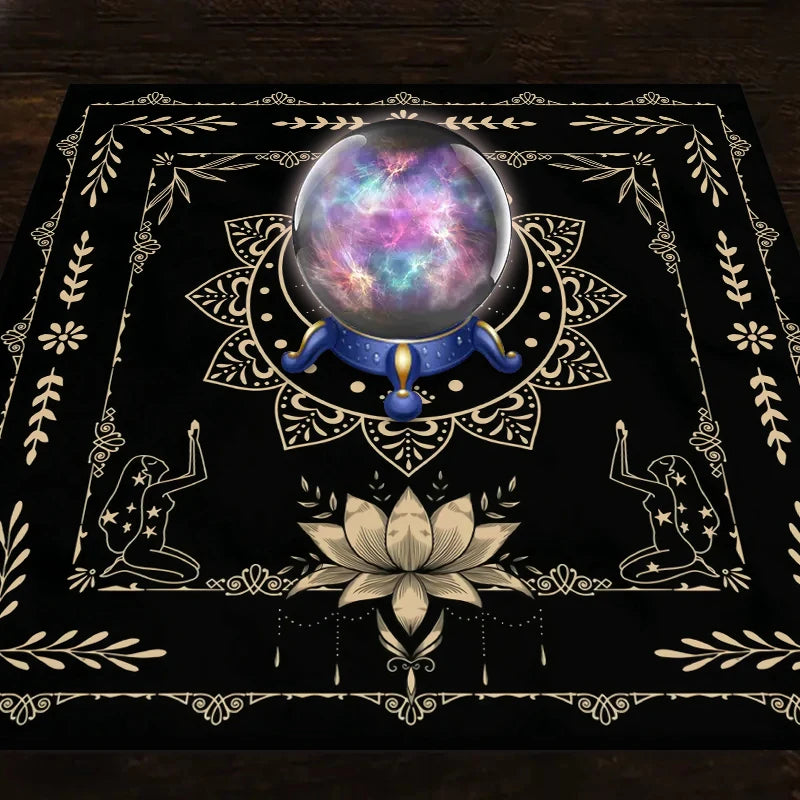 A dark mat featuring a celestial sphere, floral patterns, and silhouette figures for tarot readings.