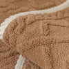 Close-up of a brown jacquard velvet fabric with white piping texture.