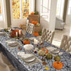 A table set with a black spider web lace runner featuring orange and green pumpkins for Halloween decor.