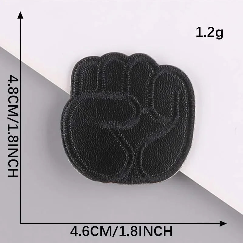 A black embroidered leather patch shaped like a palm print, measuring 4.6cm by 4.8cm.