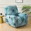 A teal and white floral print recliner sofa slipcover set placed in a bright room.