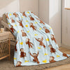 A light blue flannel throw blanket featuring a pattern of Curious George monkey characters.