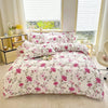 A white duvet cover set with a pink floral marble print and matching pillowcases displayed on a bed.