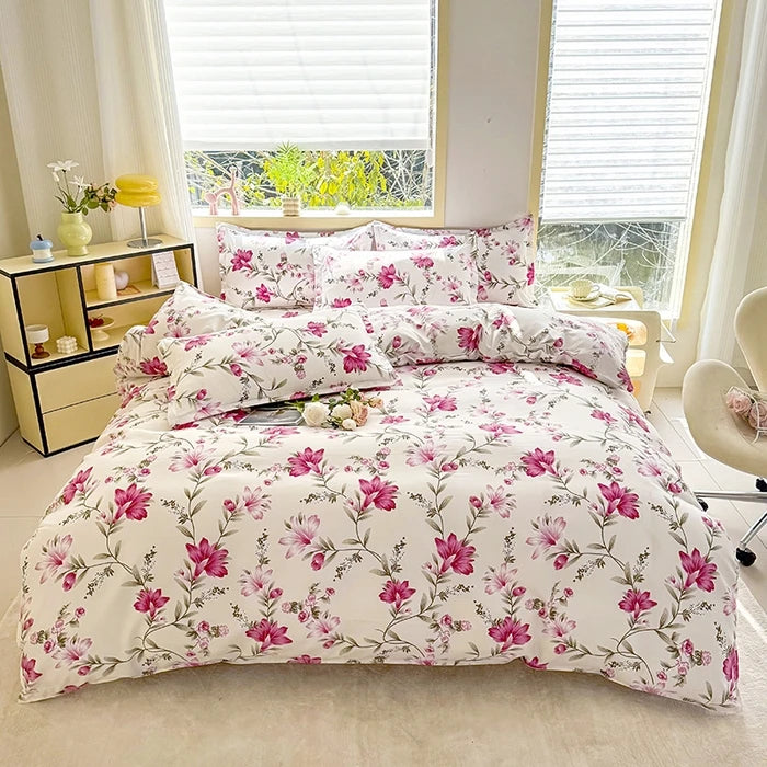 A white duvet cover set with a pink floral marble print and matching pillowcases displayed on a bed.