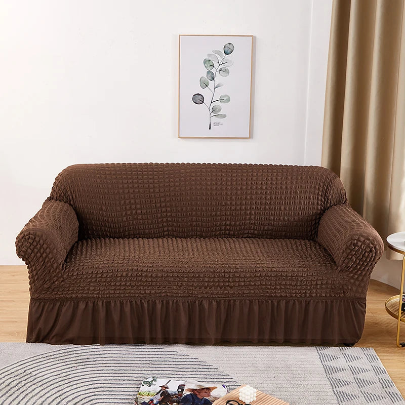 A dark brown stretch knit sofa cover with a bubble lattice texture displayed on a light gray rug.