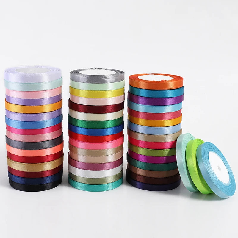 Rolls of assorted satin ribbon in various colors stacked horizontally