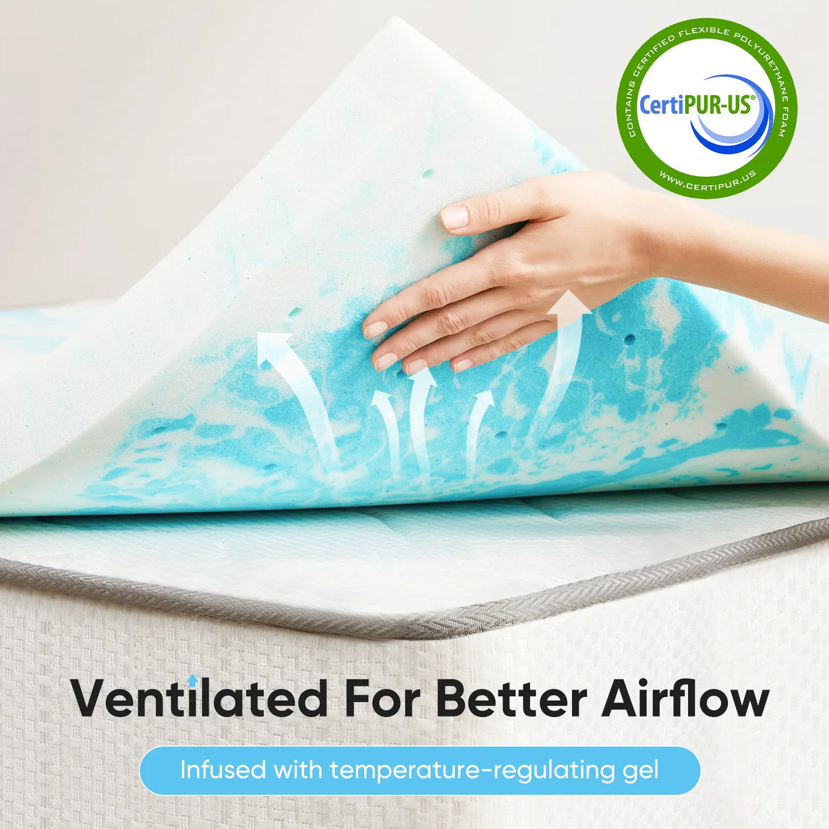 A hand is pressing a blue and white gel memory foam mattress topper, emphasizing its ventilated design for airflow.