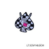 A black and white checkered patch featuring a pink hand sign embroidered on it.