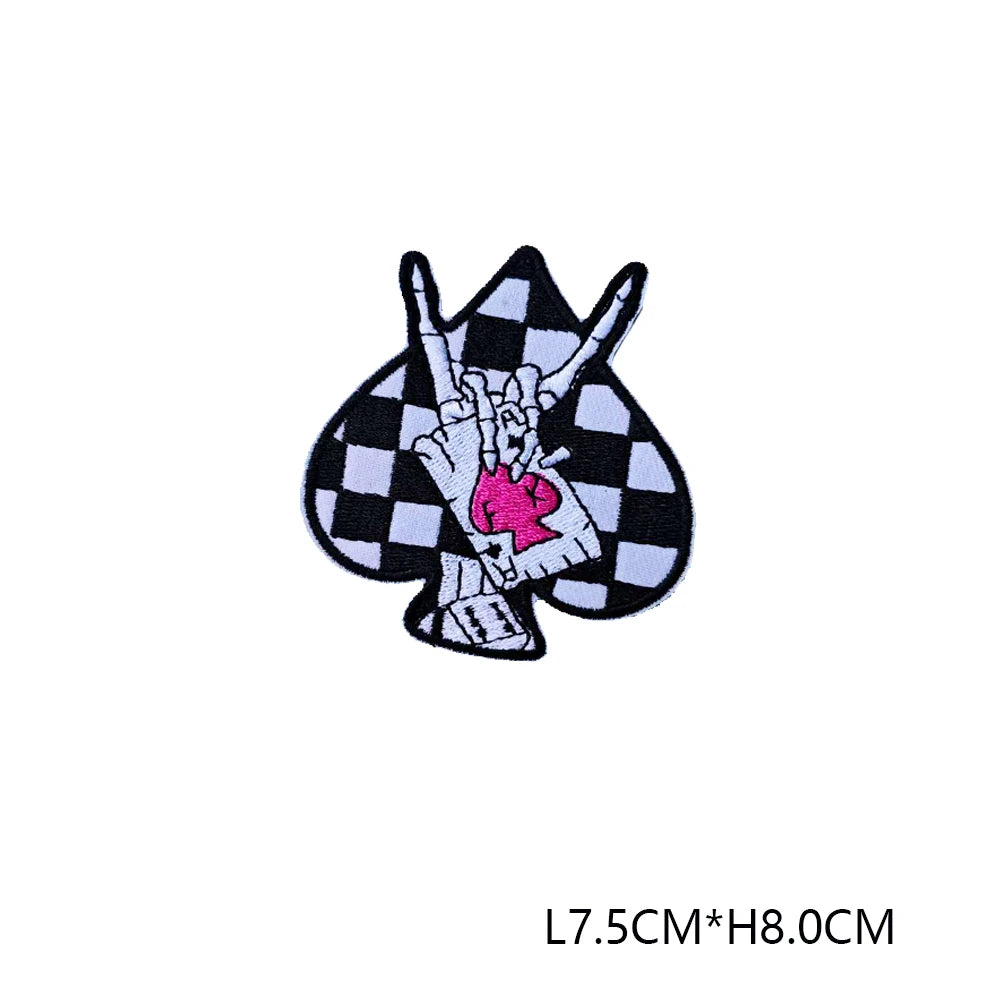 A black and white checkered patch featuring a pink hand sign embroidered on it.