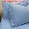 A close-up of a light blue matte solid color pillowcase resting on a bed.