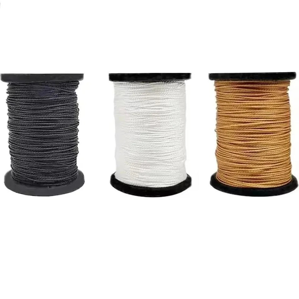 Three spools of professional leather sewing thread in black, white, and gold.