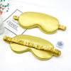 Golden silk sleep mask with ruffled edges displayed on a white background.