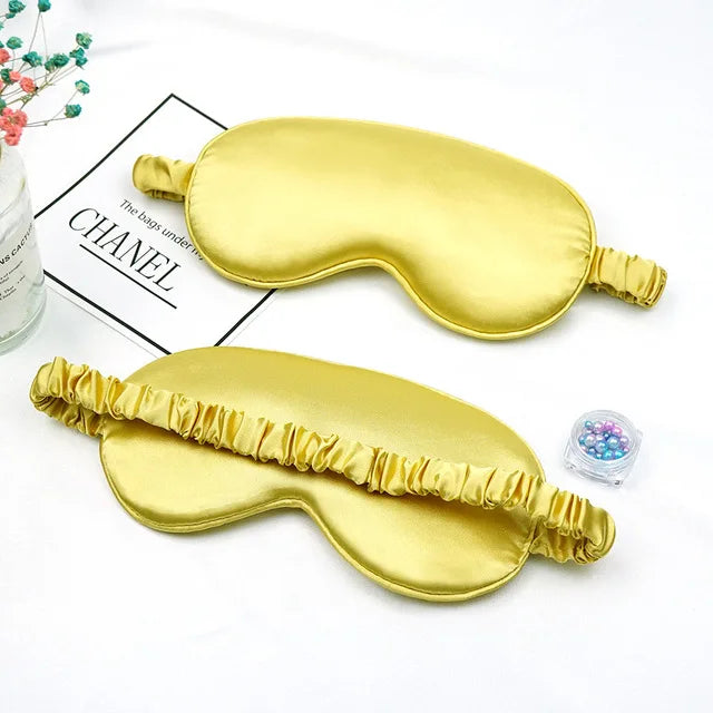 Golden silk sleep mask with ruffled edges displayed on a white background.