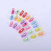 A collection of colorful plastic sewing clips in various shades including pink, green, yellow, and purple.