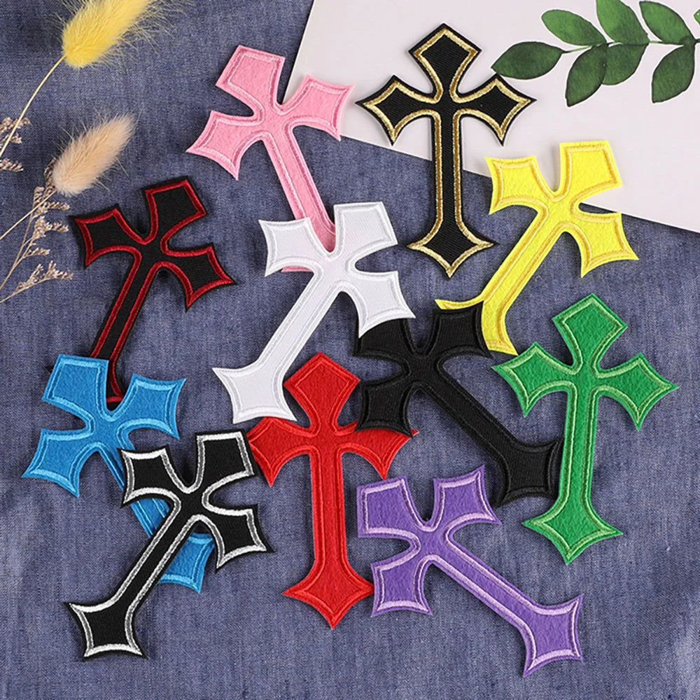 A collection of multi-color cross embroidery patches on a denim fabric.