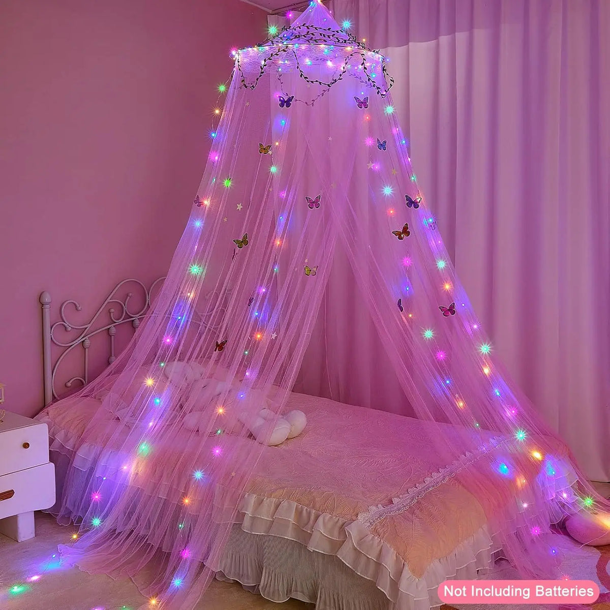 A pink mosquito net bed curtain decorated with glowing fairy lights and butterflies draped over a bed.