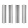 Set of four linen textured blackout curtains with grommet tops hanging on a rod