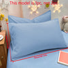 A light blue matte solid color pillowcase is displayed on a bed, with decorative star lights in the background.
