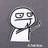 A white embroidered patch depicting a stylized, angry face with raised fingers.