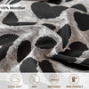 Close-up of a gray and black leopard print microfiber fabric showing its texture and drape.