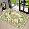A rectangular retro floral area rug with green and beige patterns is displayed on a light wood floor near a glass door.
