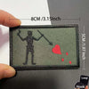 An embroidered patch depicting a silhouette of a pirate figure and a red heart with blood splatters on a dark green fabric.
